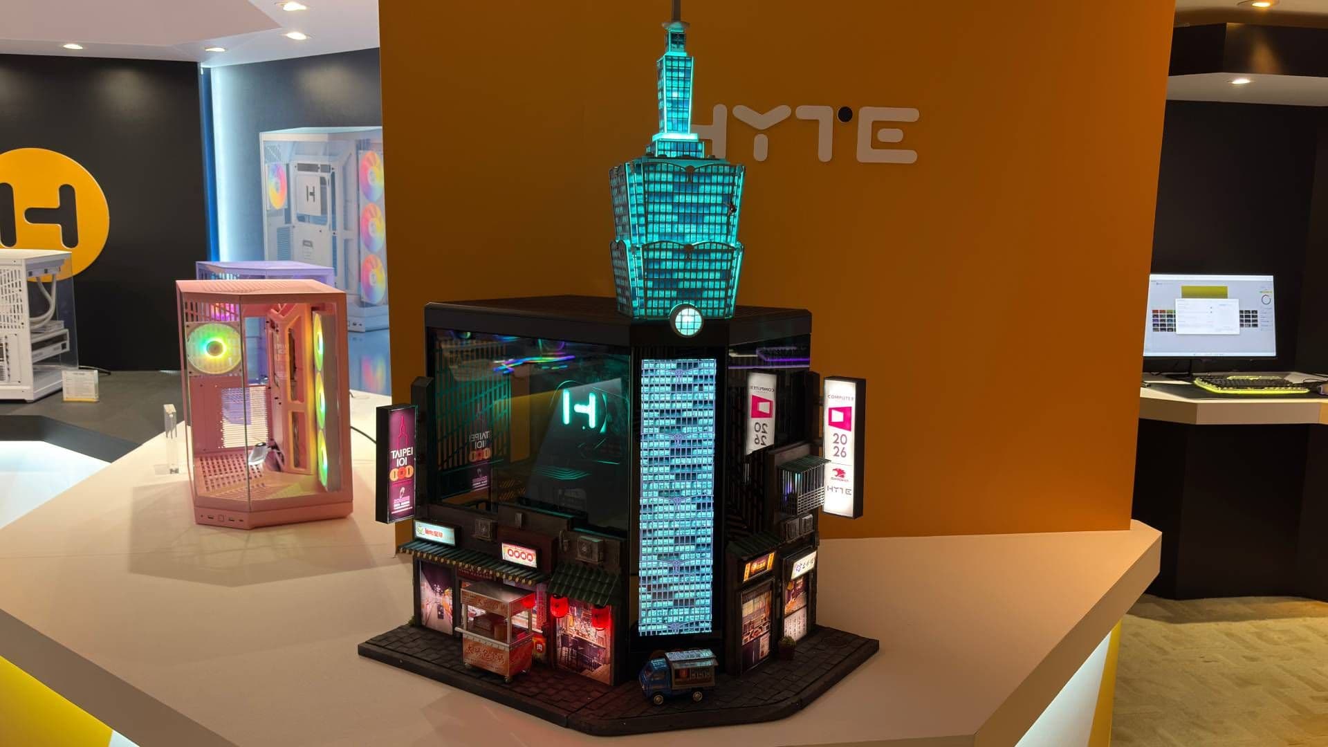 Este PC customizado em forma de arranha-céu na Computex tem uma barraca de comida na frente vendendo salsicha taiwanesa com arroz glutinoso e um escalador praticando free solo na lateral